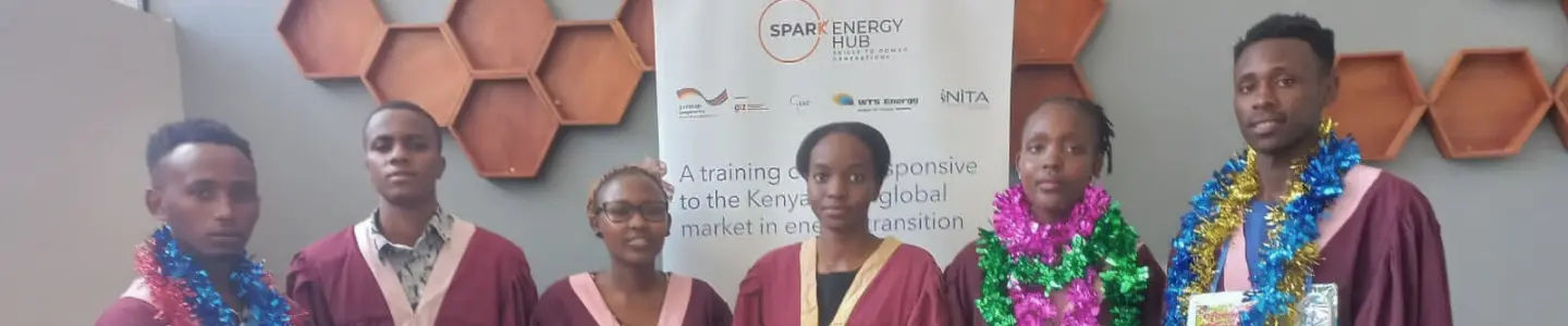 Matilda, graduate from Spark Energy Hub standing in the middle of the photo with more graduates from her class on both of her sides
