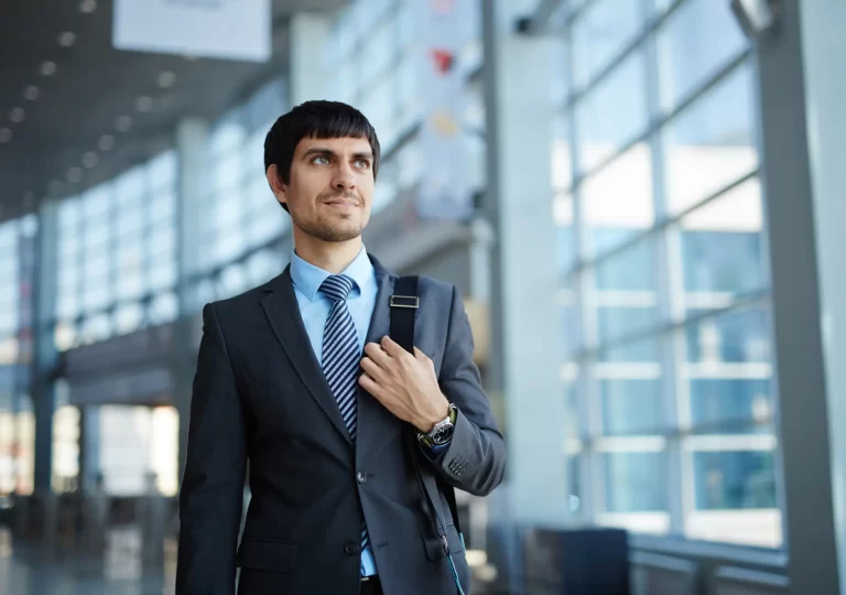 executive in a suit is walking in front of the camera with a smile