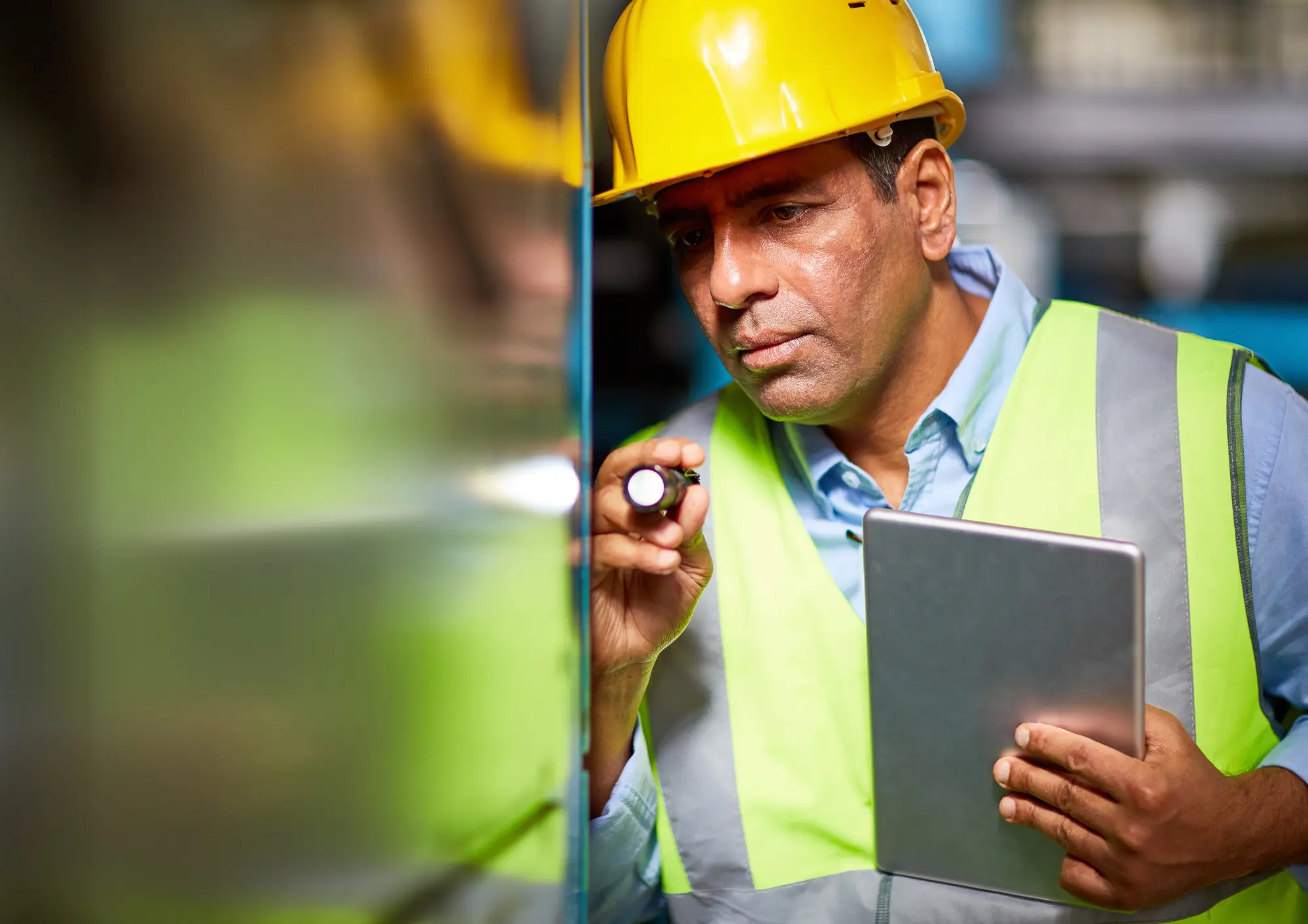 man wearing safety gear inspecting equipment