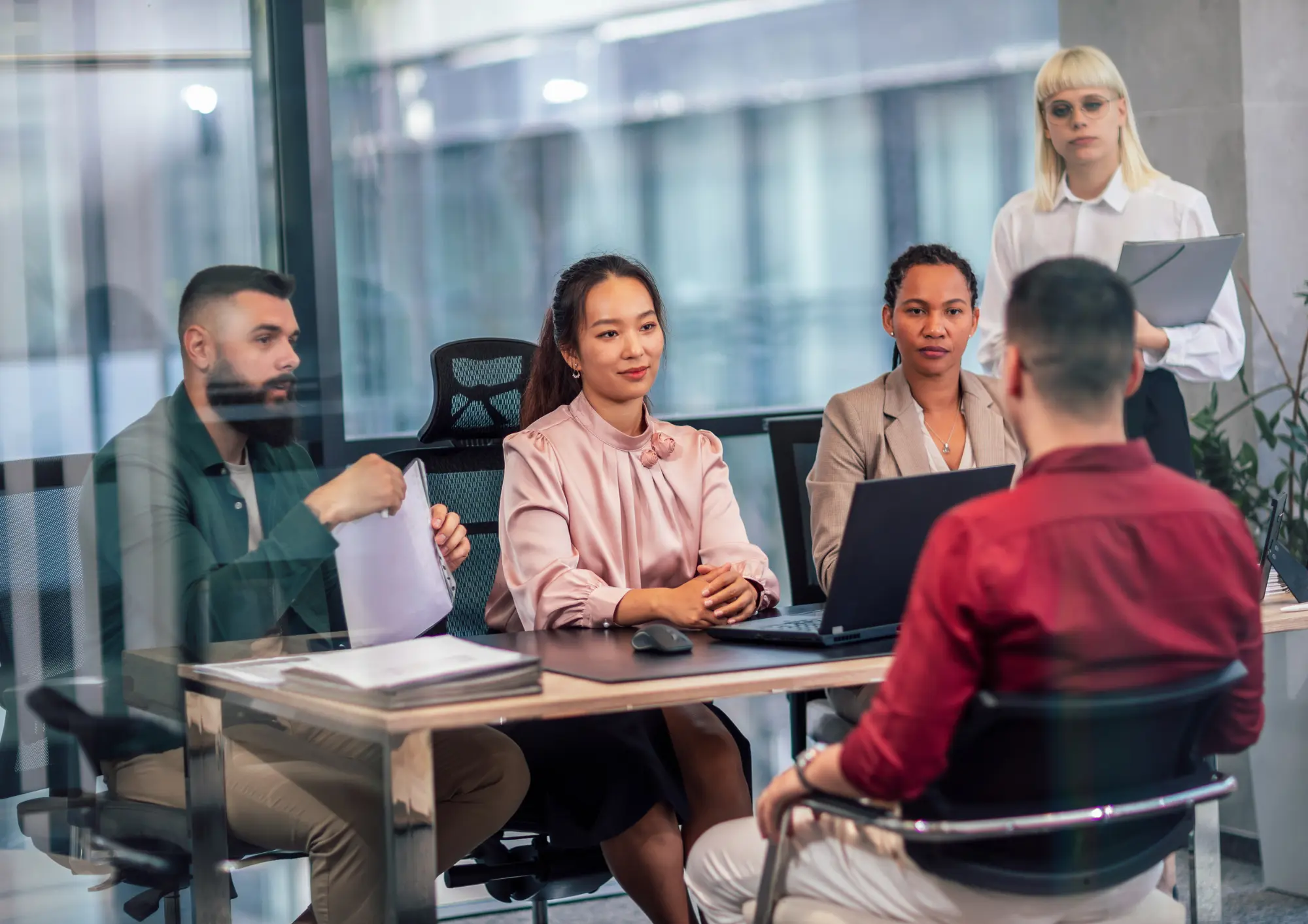 A group of recruiters are conducting an interview is conducting in the office with an applicant