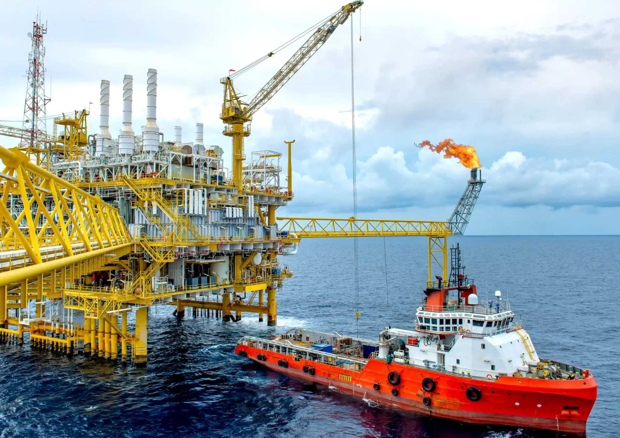 Support vessel operating next to an offshore oil platform, representing specialized engineering services in Mexico.