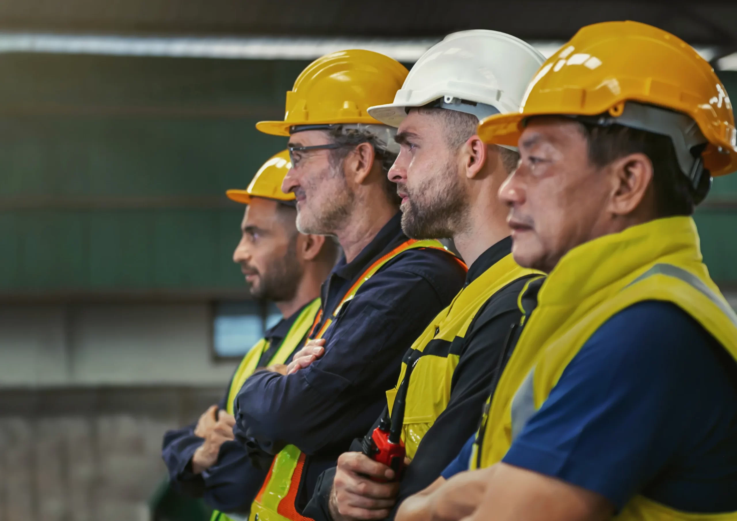 A team of industrial workers in safety gear standing in a row, symbolizing recruitment and workforce solutions in manufacturing and construction