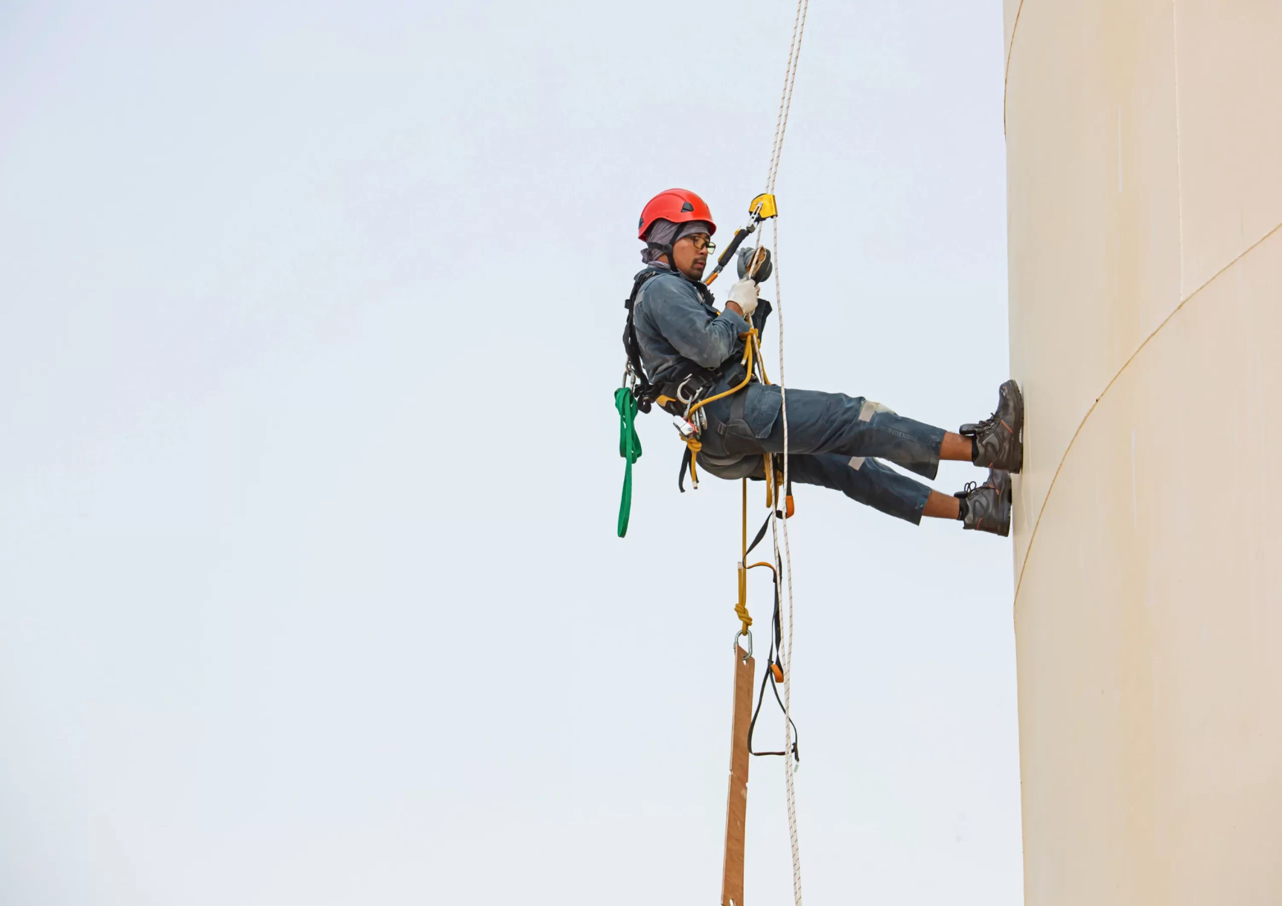 Technician performing rope access work on a vertical structure, showcasing operations and maintenance in Kenya.