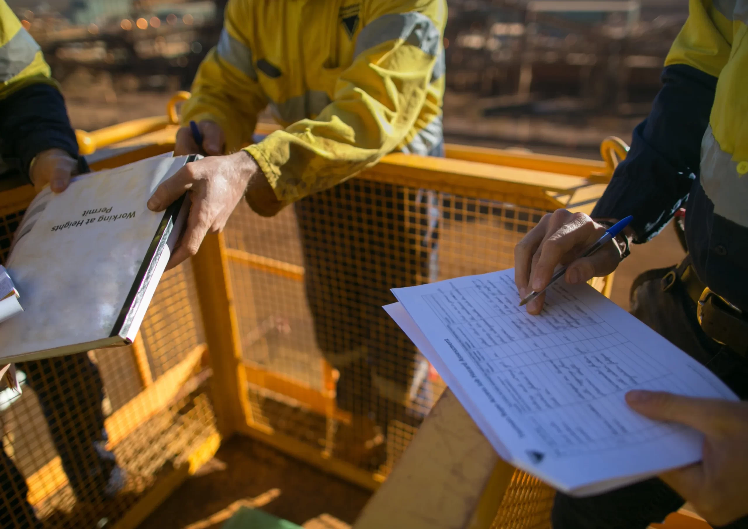 Workers filling out safety permits and checklists on-site, supporting operations and maintenance in Kenya.