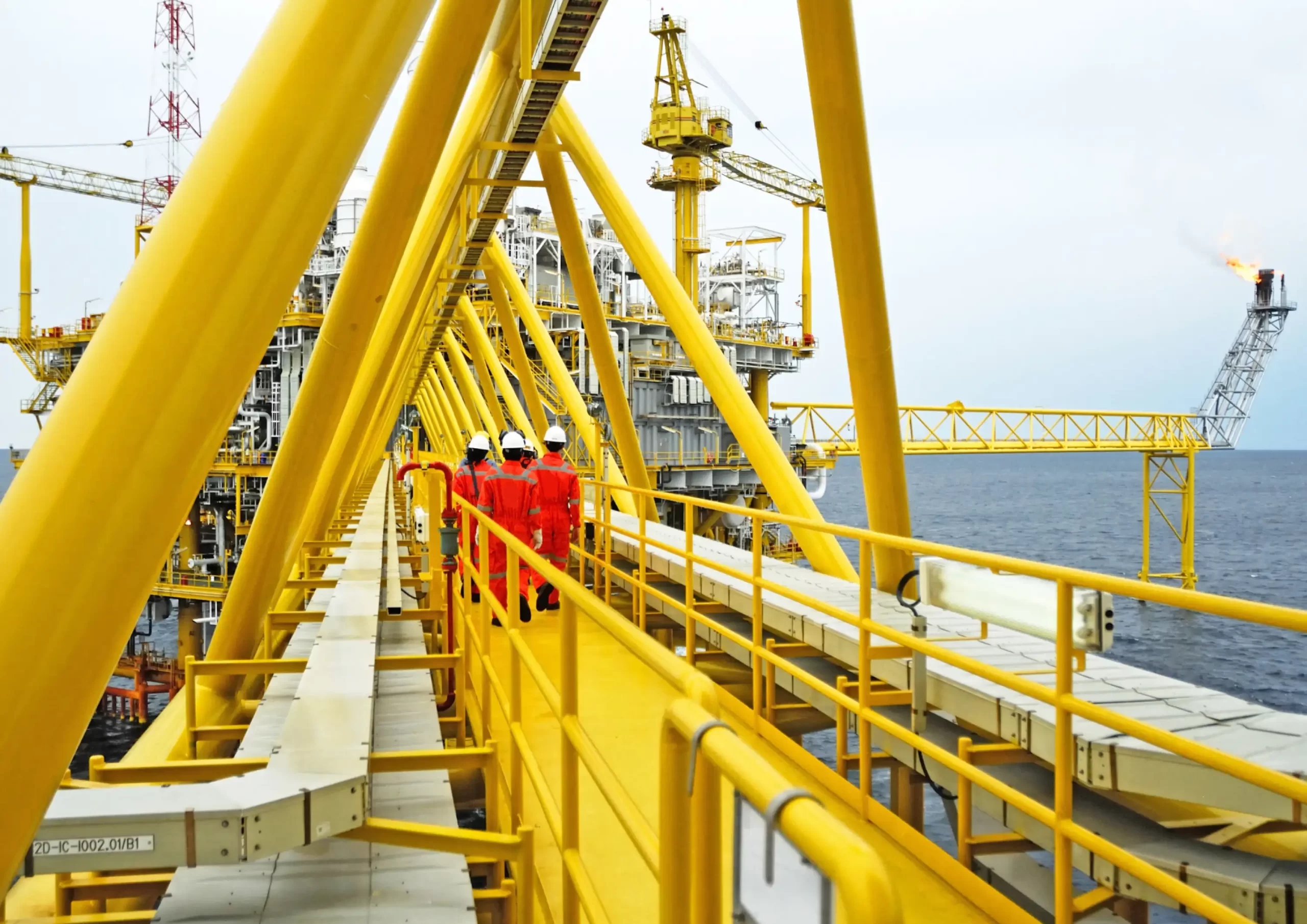 Offshore crew walking along a platform bridge as part of O&M services for the offshore and marine industry.