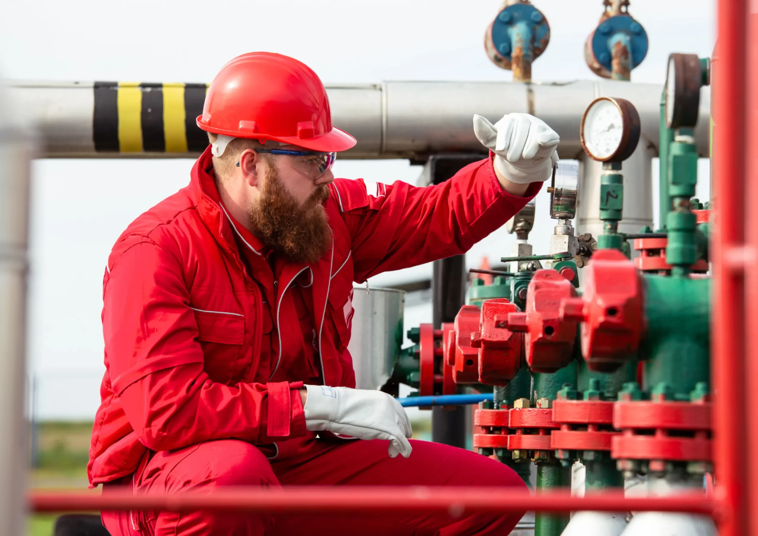 Technician inspecting pressure gauges and valves during oil and gas operations and maintenance.
